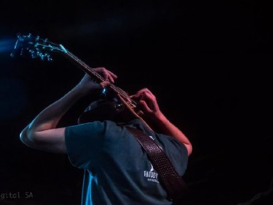 Joe playing guitar behind head 2